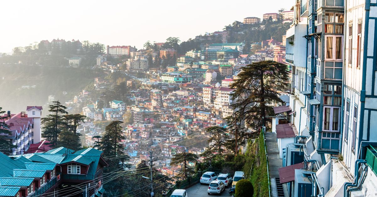Colorful hillside cityscape with vibrant homes and lush greenery under daylight.